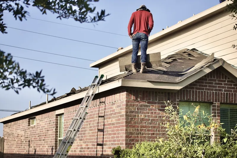 Professional roofer working on a residential roof in Oak Island
